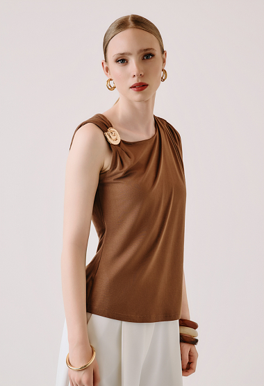 Sleeveless blouse with decorative brooch