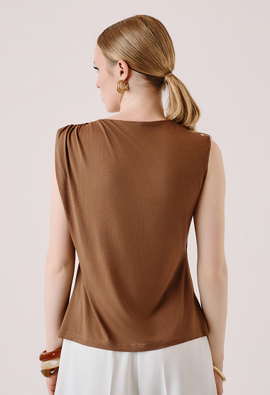 Sleeveless blouse with decorative brooch