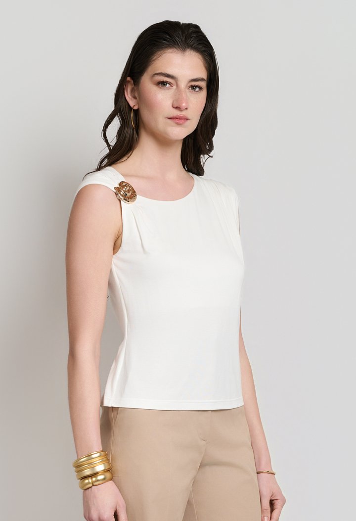 Sleeveless blouse with decorative brooch