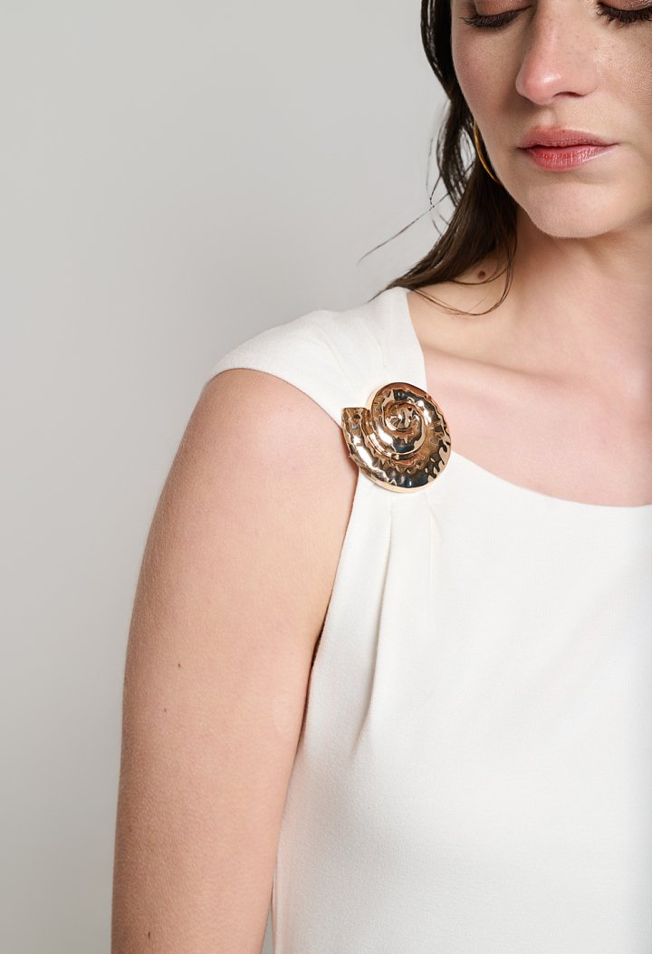 Sleeveless blouse with decorative brooch