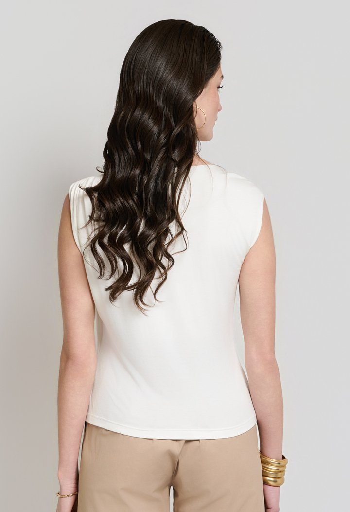 Sleeveless blouse with decorative brooch