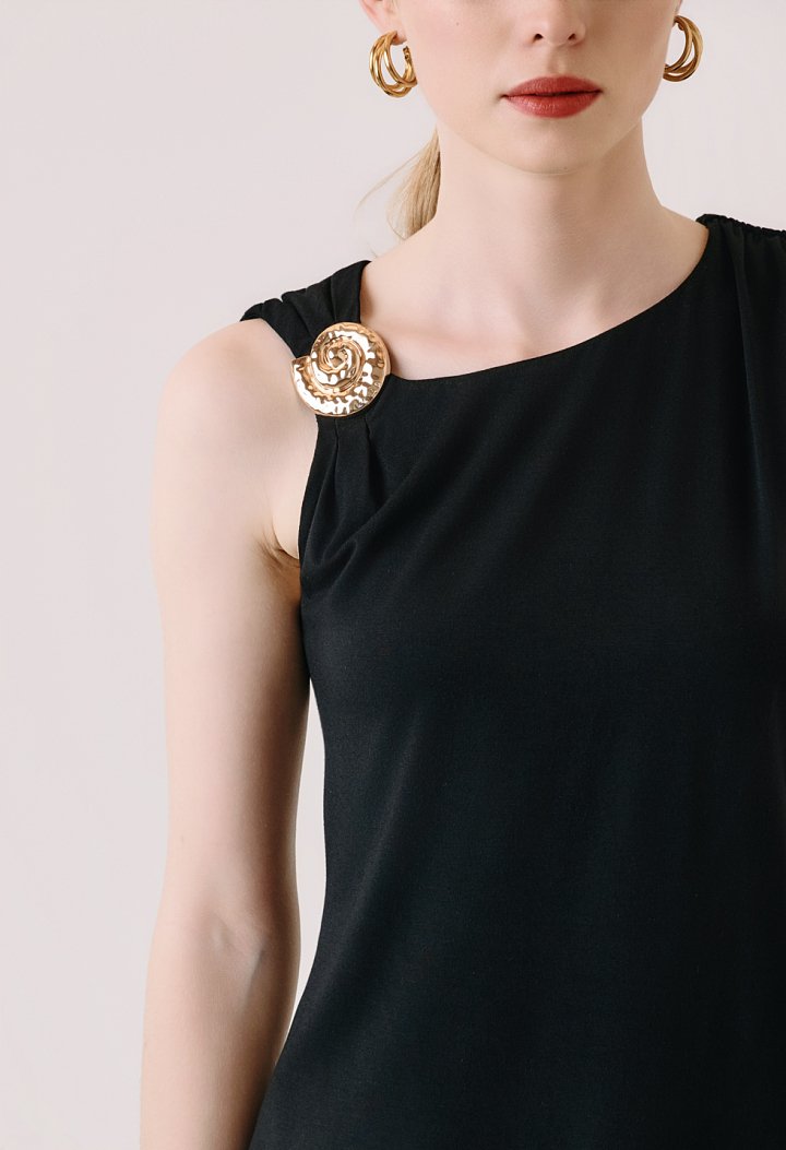 Sleeveless blouse with decorative brooch