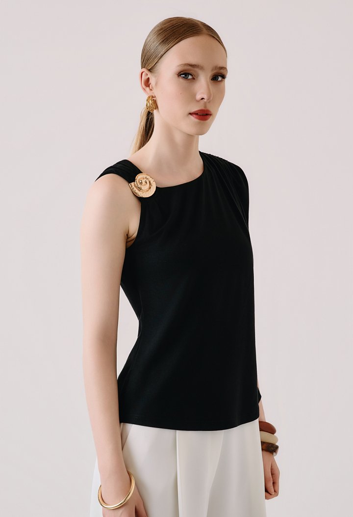 Sleeveless blouse with decorative brooch
