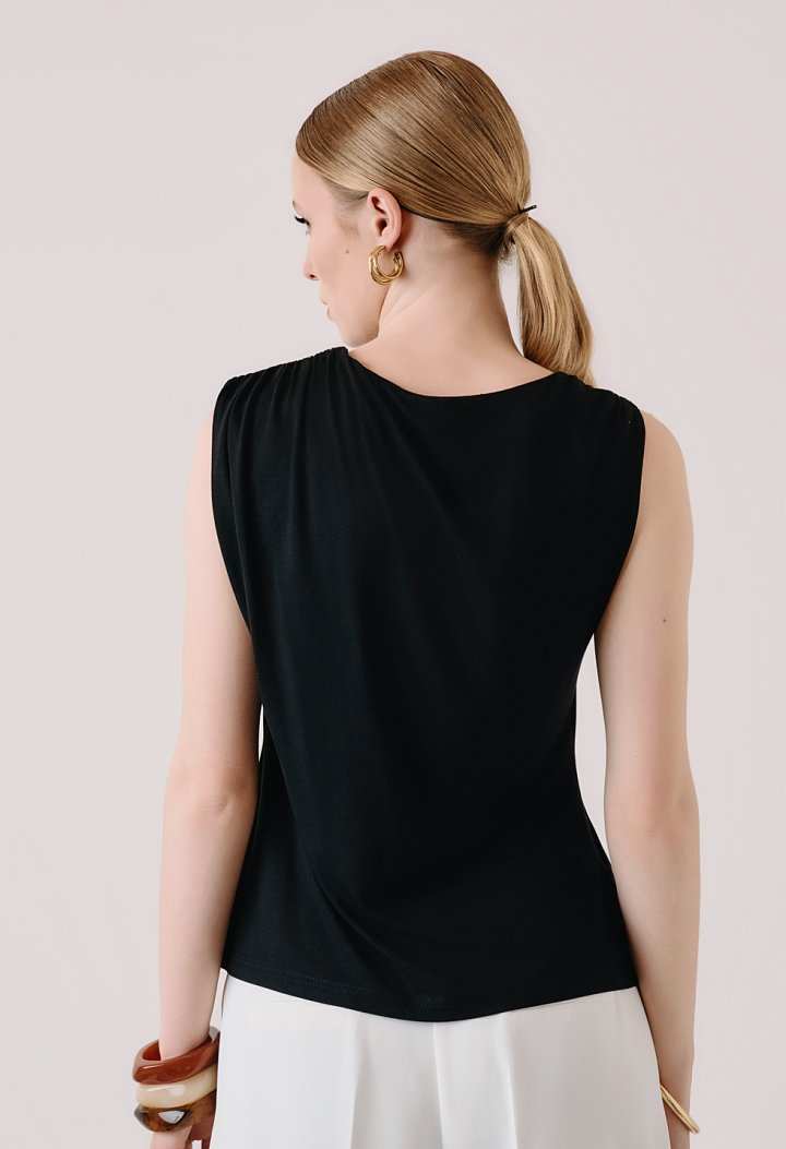 Sleeveless blouse with decorative brooch